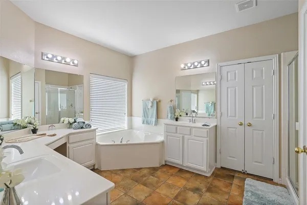 a large bathroom with a double vanity sink mirror and bathtub
