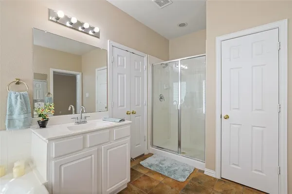 a bathroom with a double vanity sink mirror and shower