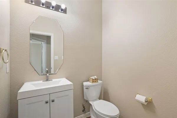 a bathroom with a toilet a sink and mirror