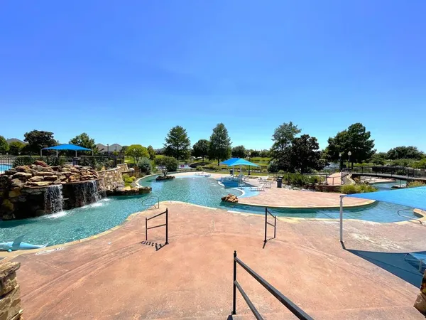 a view of a swimming pool and lounge chairs in patio