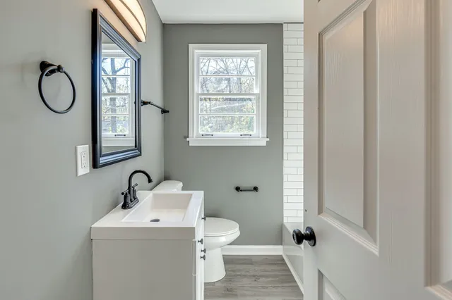 a bathroom with a toilet sink vanity and mirror