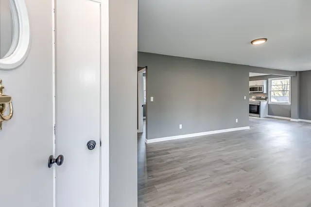 a view of a big room with wooden floor and windows