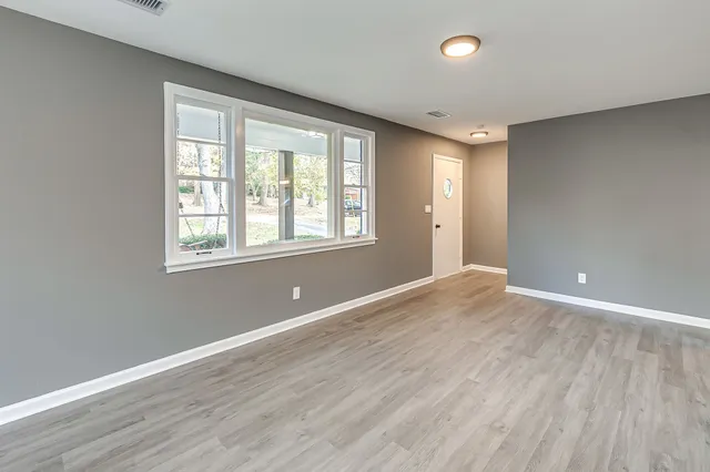 wooden floor in an empty room with a window
