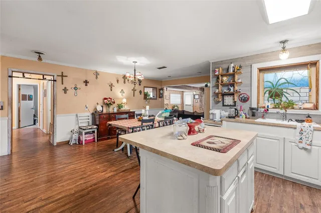 a living room with stainless steel appliances kitchen island granite countertop a sink and a stove