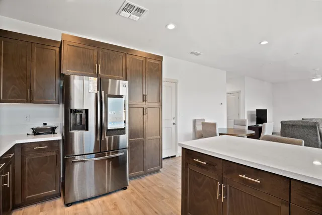a kitchen with stainless steel appliances a refrigerator and wooden floor