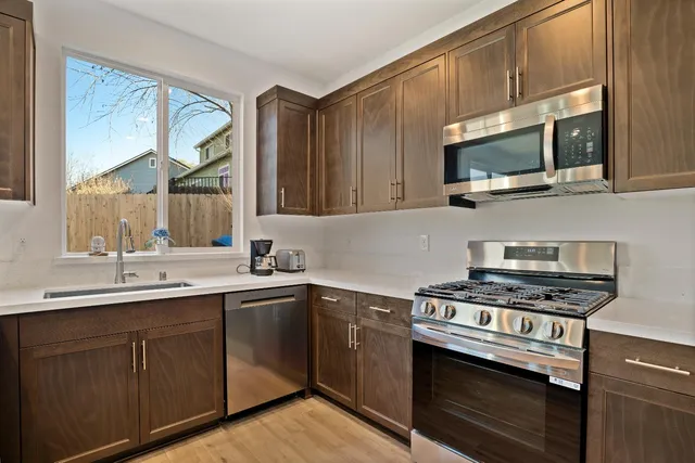 a kitchen with stainless steel appliances a sink cabinets and a stove top oven