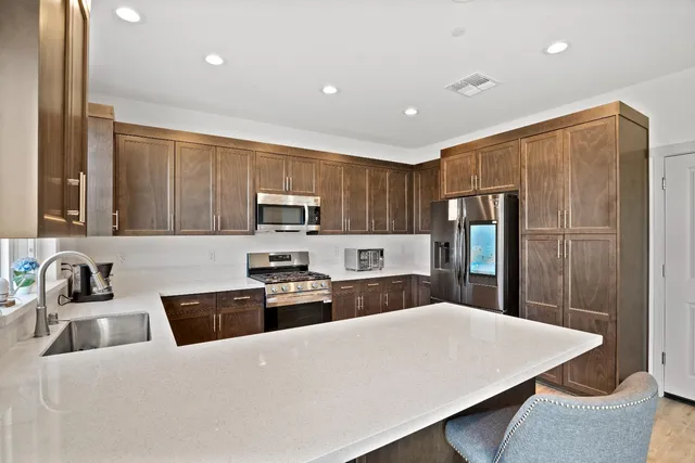 a kitchen with stainless steel appliances a refrigerator sink stove microwave and cabinets