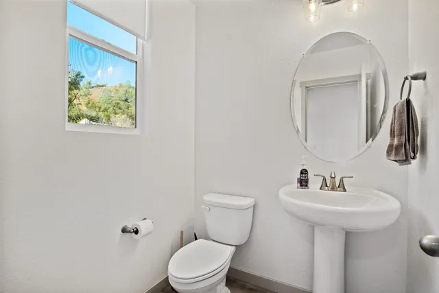 a bathroom with a toilet a sink and mirror