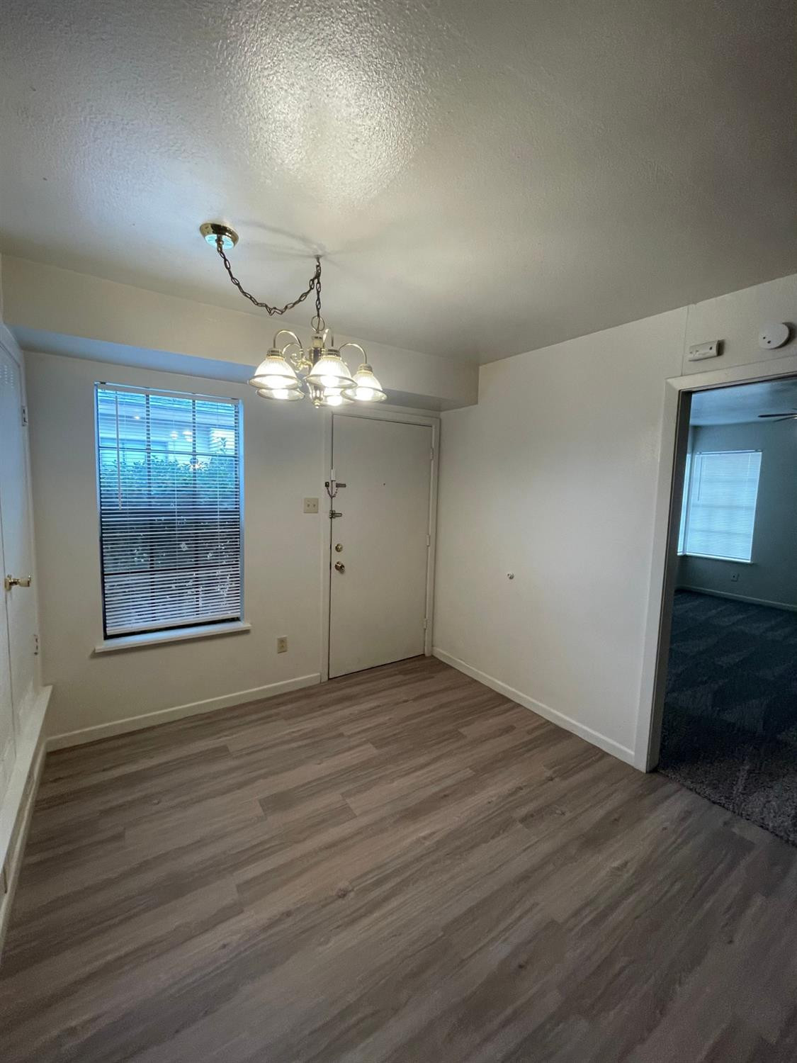 2121 33rd Street, Unit A Lubbock, TX 79411 - Photo 3 of 6 an empty room with wooden floor and windows