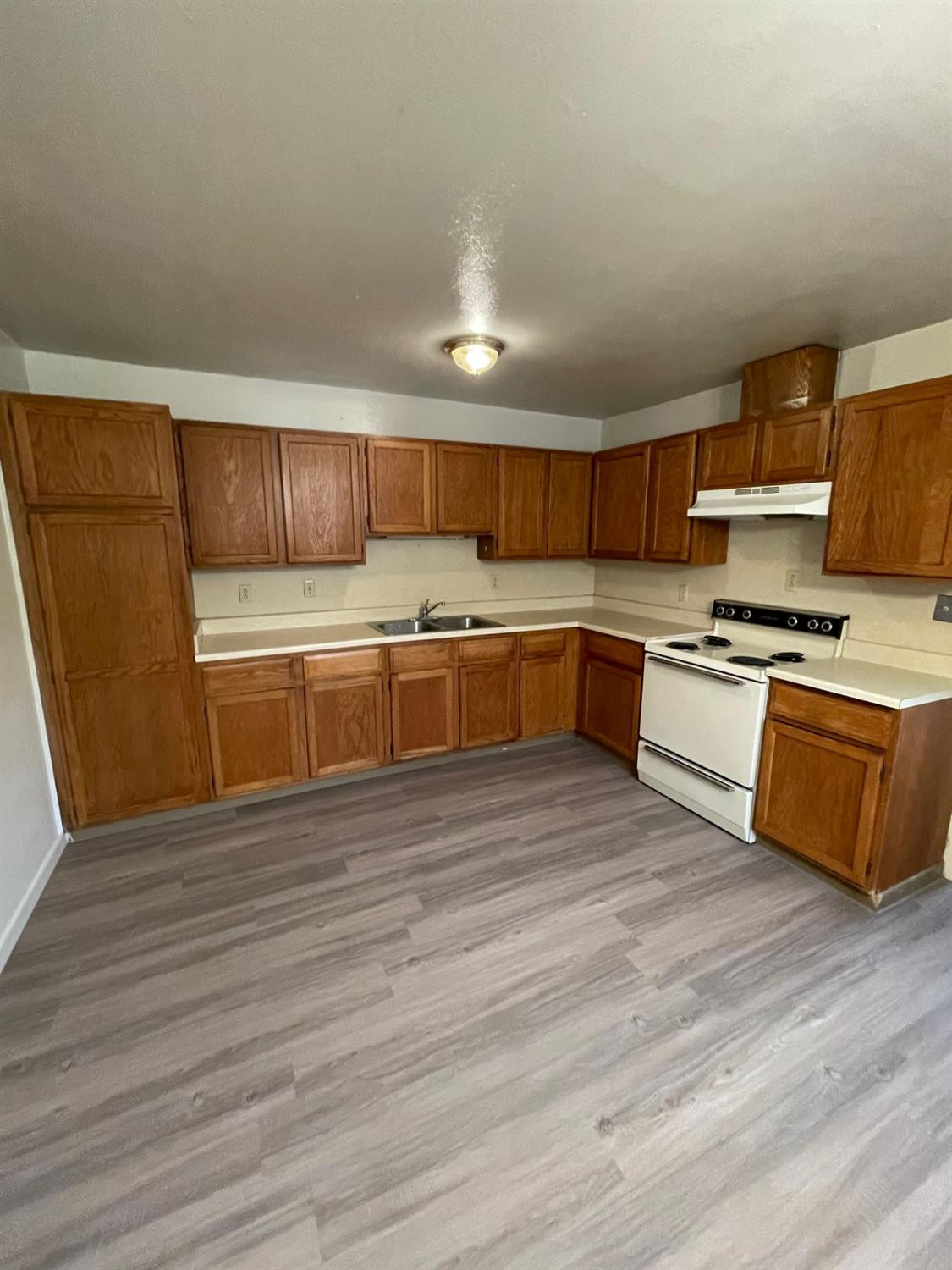 2121 33rd Street, Unit A Lubbock, TX 79411 - Photo 5 of 6 a kitchen with stainless steel appliances granite countertop a stove a sink and a refrigerator