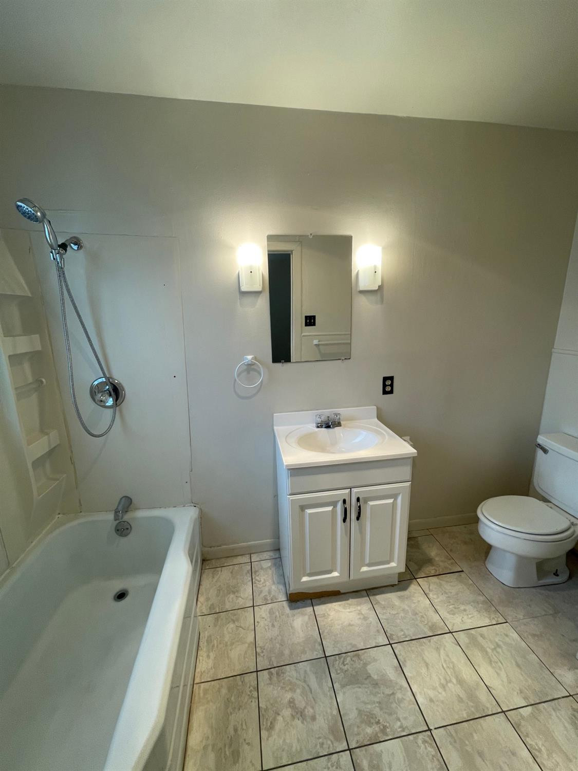 2121 33rd Street, Unit A Lubbock, TX 79411 - Photo 6 of 6 a bathroom with a sink a toilet and shower