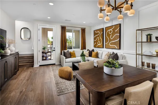 a living room with furniture a chandelier and a dining room