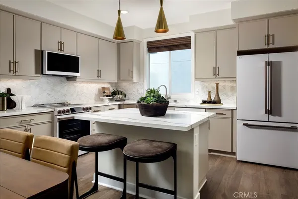 a kitchen with stainless steel appliances a stove a sink a microwave a refrigerator and cabinets
