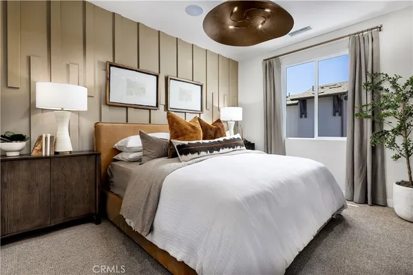 a bedroom with a large bed and a chandelier