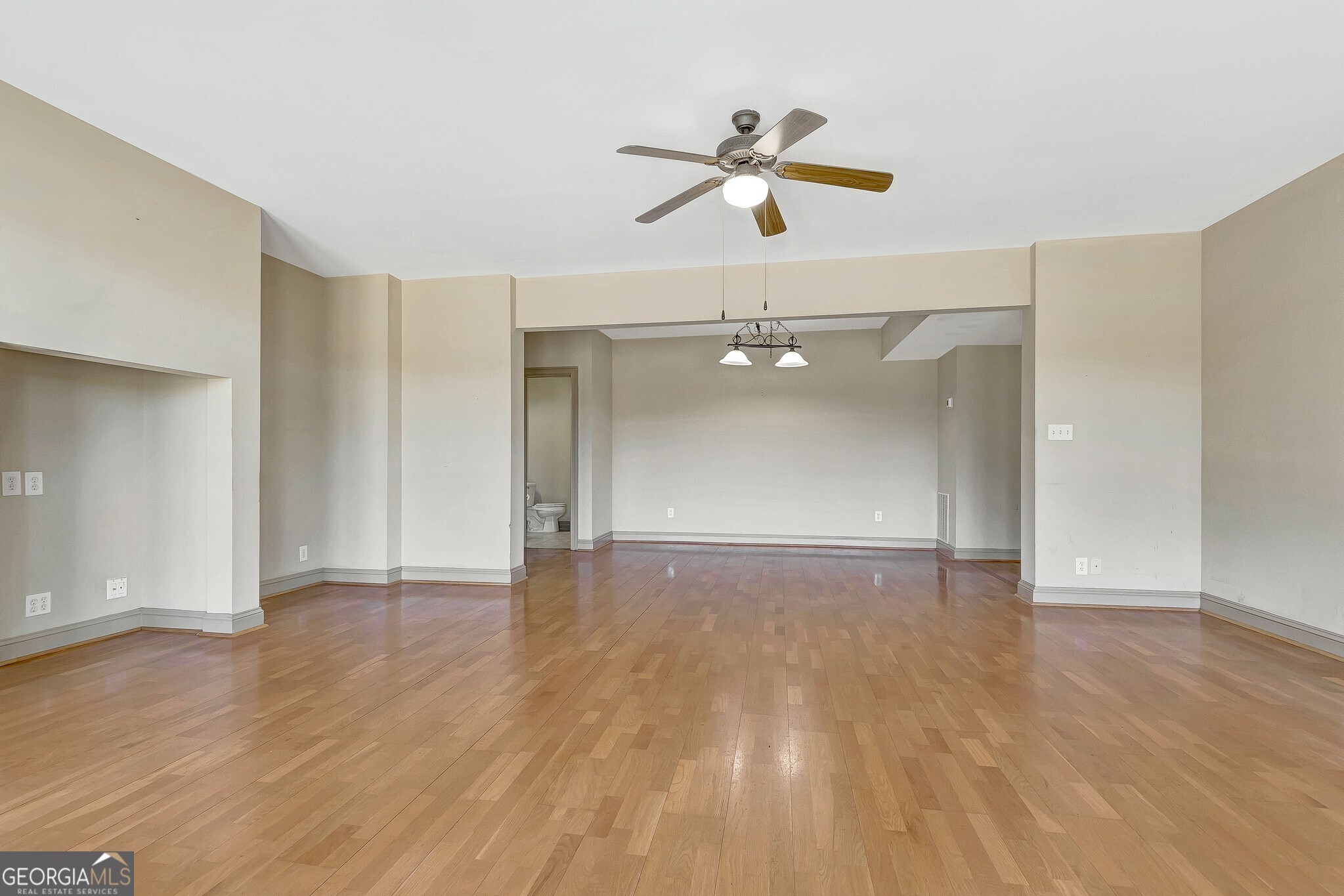 220 Joe Roberts Road Newnan, GA 30263 - Photo 68 of 108 an empty room with wooden floor chandelier fan and windows