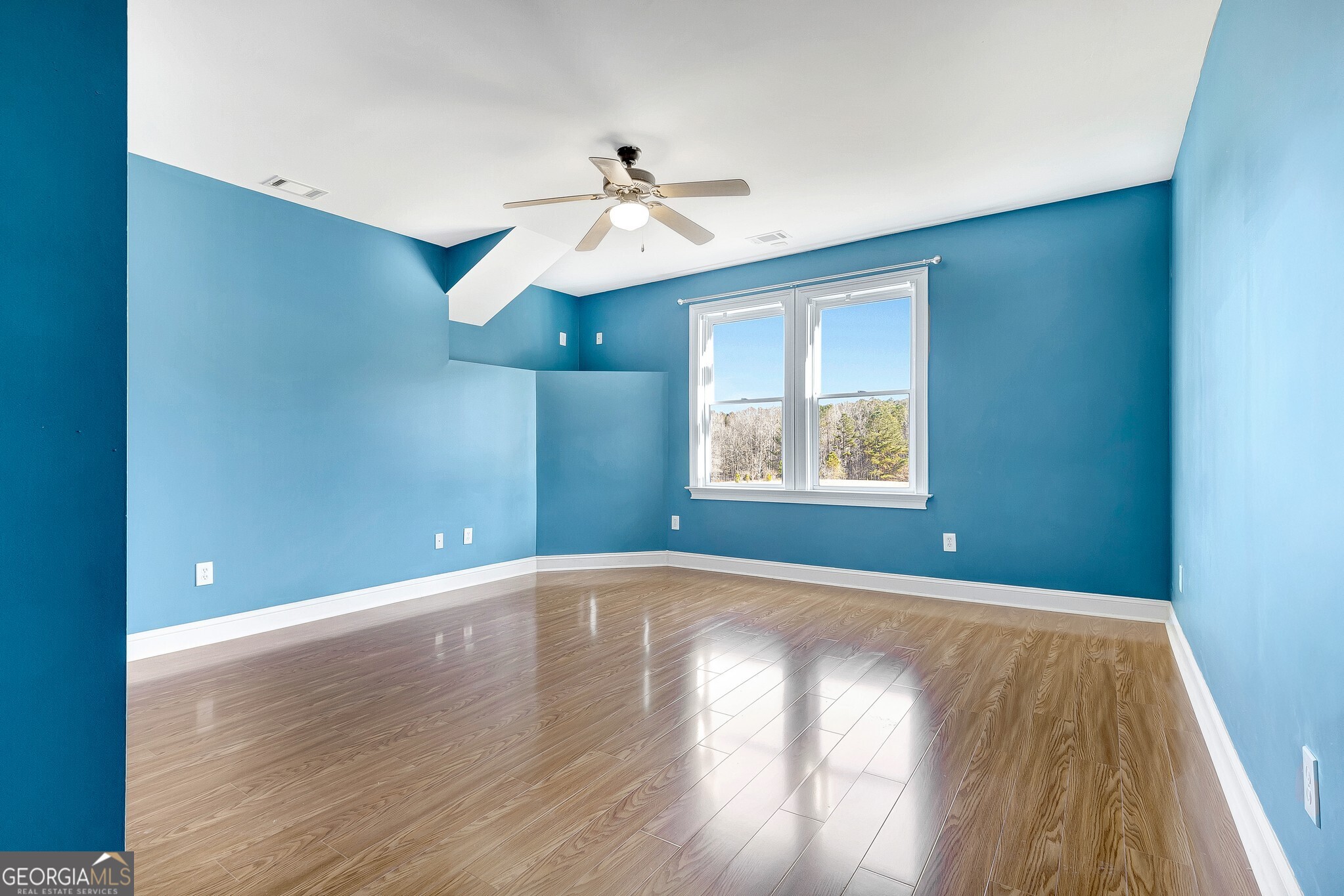 220 Joe Roberts Road Newnan, GA 30263 - Photo 74 of 108 an empty room with wooden floor chandelier fan and windows