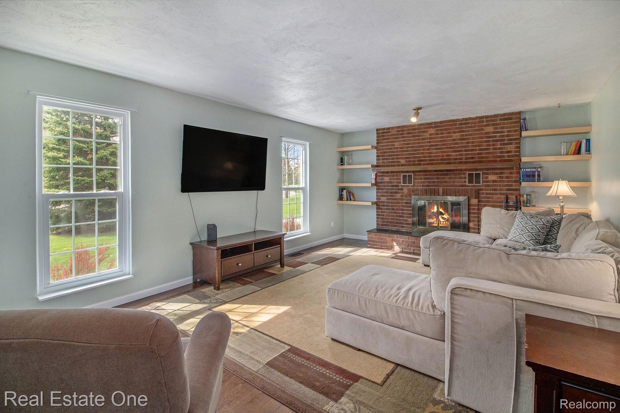 1296 Barneswood Lane Rochester, MI 48306 - Photo 4 of 32 Living Room with large windows looking toward the front of the house boasting a natural wood fireplace to create an enchanted atmosphere to your evenings with friends