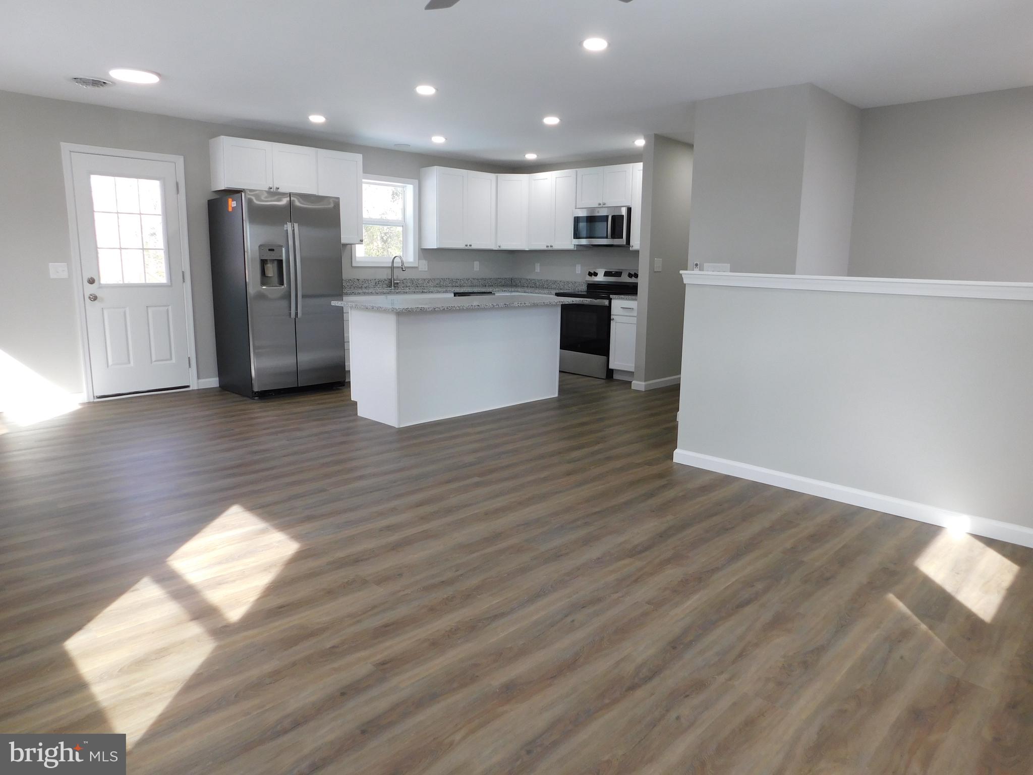 9458 Benson Road Lincoln, DE 19960 - Photo 11 of 38 a open kitchen with stainless steel appliances granite countertop a refrigerator sink and wooden cabinets