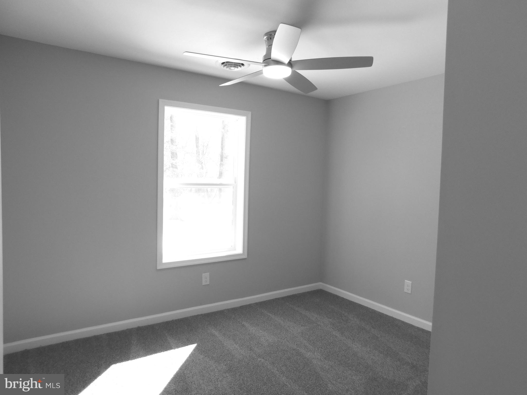 9458 Benson Road Lincoln, DE 19960 - Photo 17 of 38 an empty room with a window and a fan