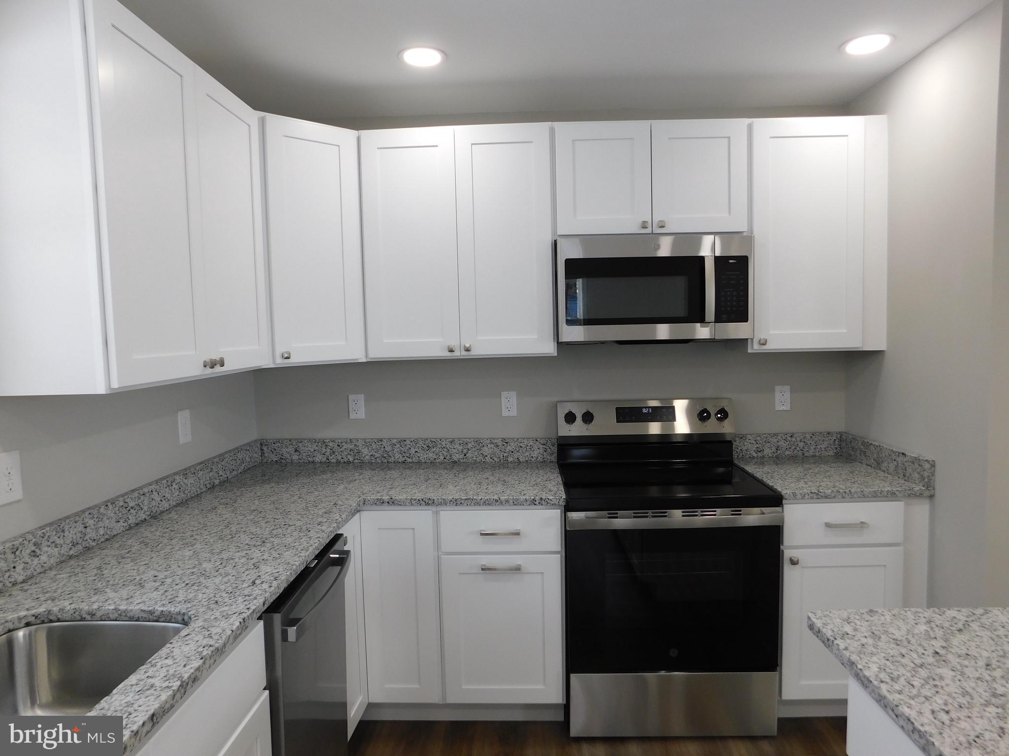 9458 Benson Road Lincoln, DE 19960 - Photo 5 of 38 a kitchen with granite countertop white cabinets and stainless steel appliances