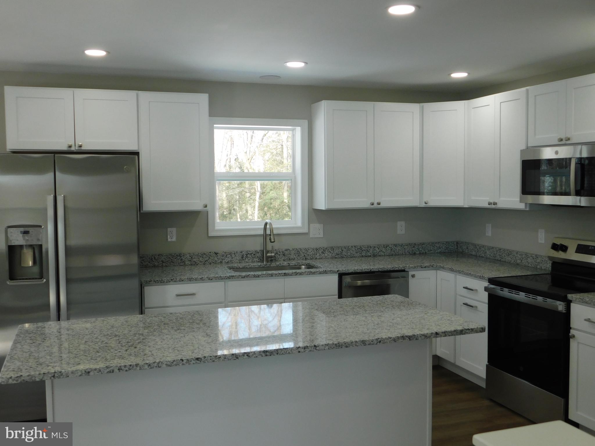 9458 Benson Road Lincoln, DE 19960 - Photo 9 of 38 a kitchen with stainless steel appliances granite countertop a sink a stove a refrigerator a microwave and cabinets