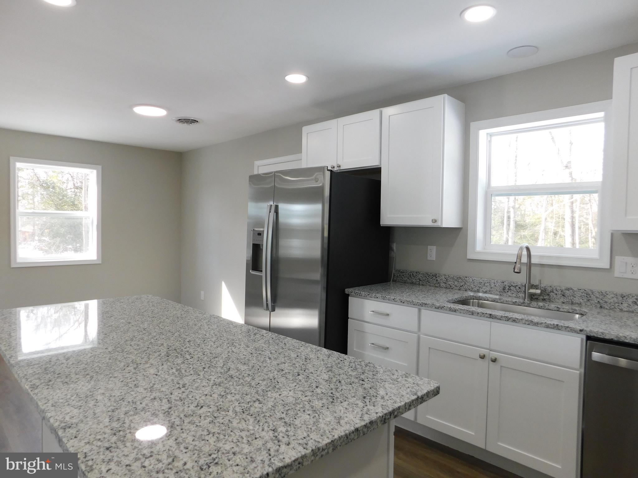9458 Benson Road Lincoln, DE 19960 - Photo 10 of 38 a kitchen with stainless steel appliances granite countertop a sink a refrigerator and a granite counter tops