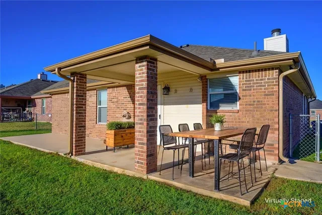 a view of a house with backyard porch and sitting area