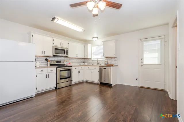 a kitchen with white cabinets stainless steel appliances and sink