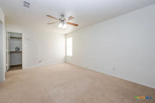 an empty room with a fan and a window