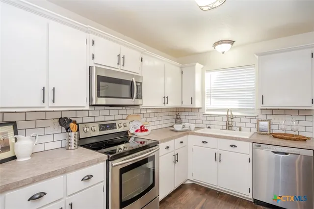 a kitchen with appliances cabinets and a sink
