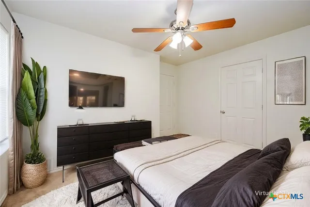 a bedroom with a bed a television and potted plant
