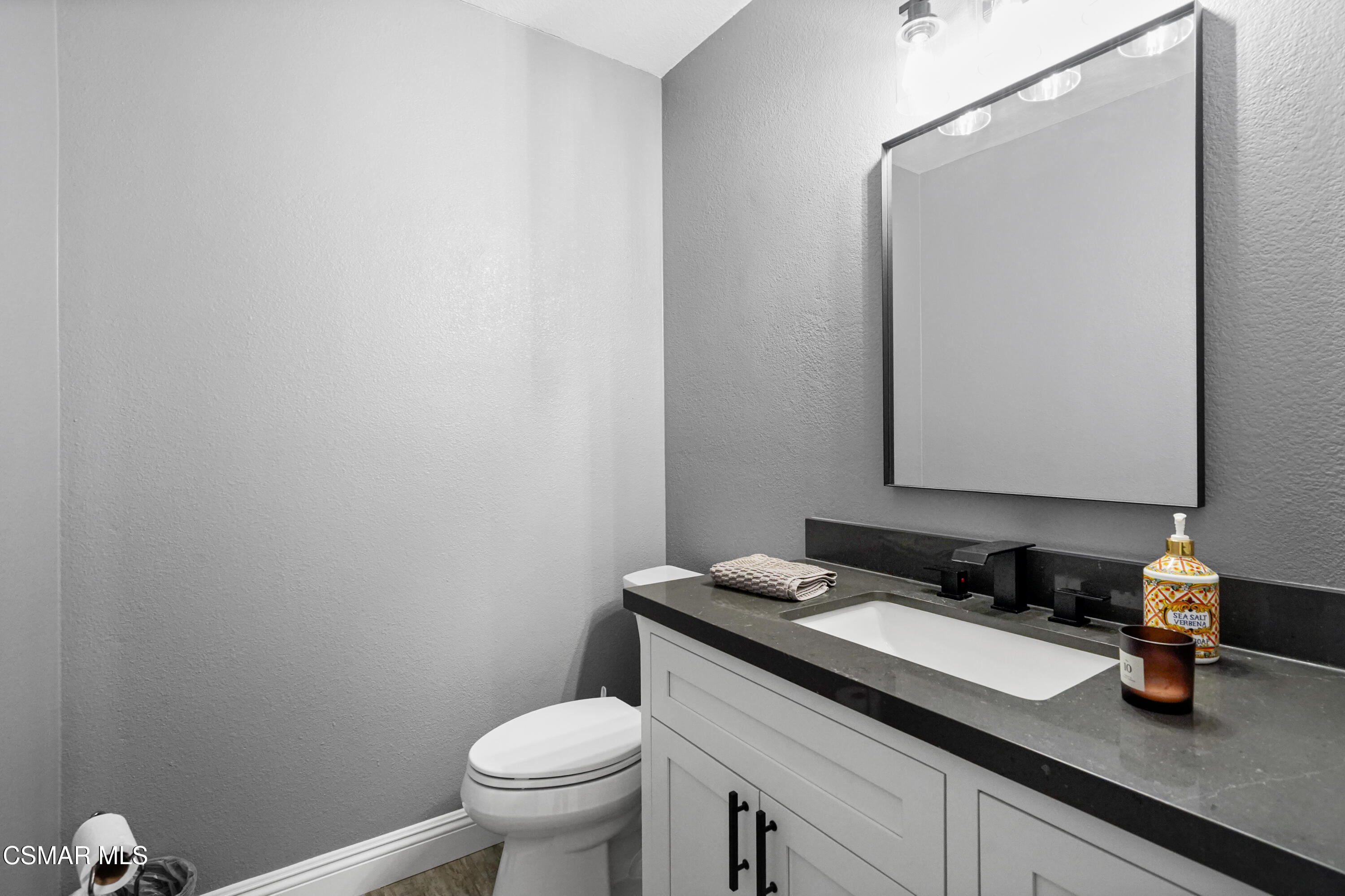 14291 Clemson Street Moorpark, CA 93021 - Photo 16 of 23 a bathroom with a granite countertop sink a toilet and mirror
