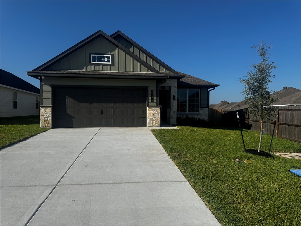 4795 Holm Oak Road Bryan, TX 77845 - Photo 1 of 17 View of front facade with stone siding, board and batten siding, concrete driveway, and an attached garage