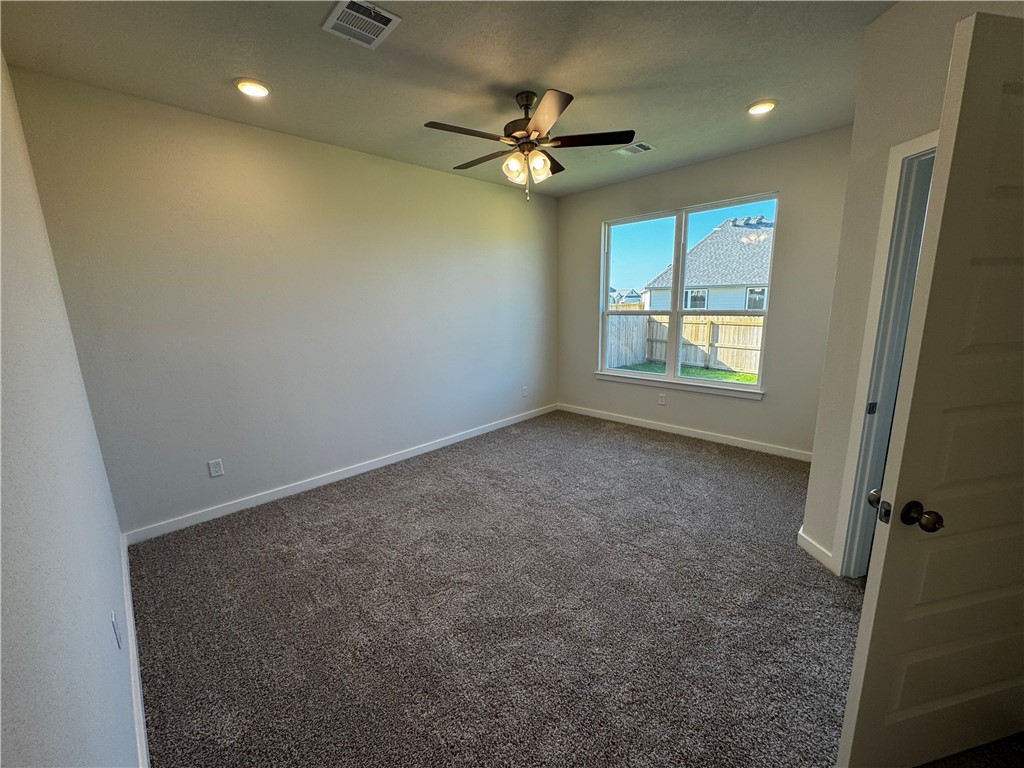 4795 Holm Oak Road Bryan, TX 77845 - Photo 12 of 17 Unfurnished room with dark carpet, recessed lighting, and ceiling fan