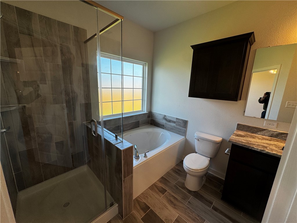4795 Holm Oak Road Bryan, TX 77845 - Photo 13 of 17 Bathroom featuring vanity, wood finish floors, a shower stall, and a garden tub