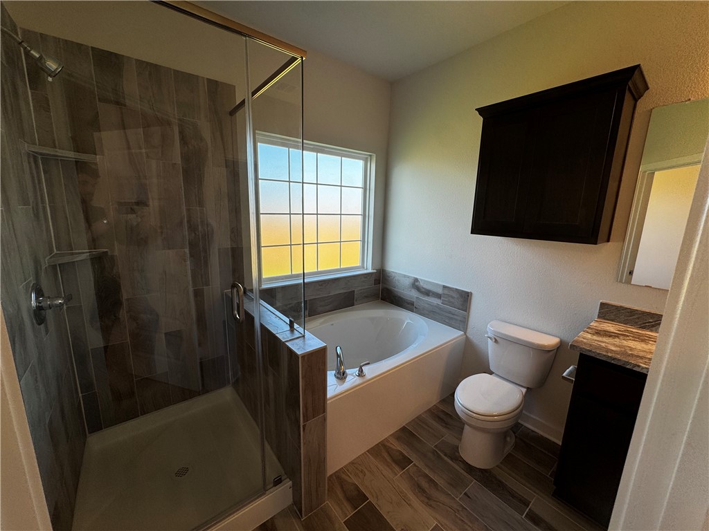 4795 Holm Oak Road Bryan, TX 77845 - Photo 15 of 17 Full bathroom with vanity, a stall shower, wood finish floors, and a bath
