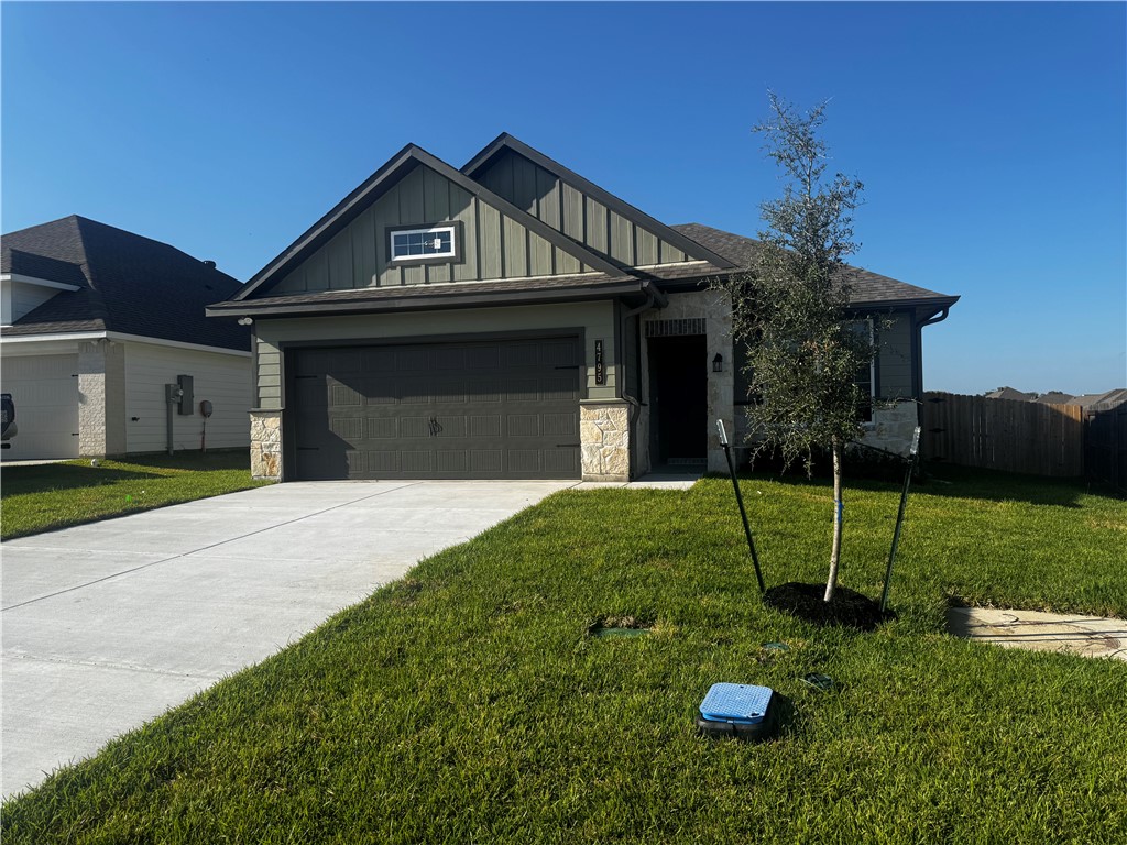 4795 Holm Oak Road Bryan, TX 77845 - Photo 2 of 17 View of front of home featuring board and batten siding, stone siding, concrete driveway, and an attached garage