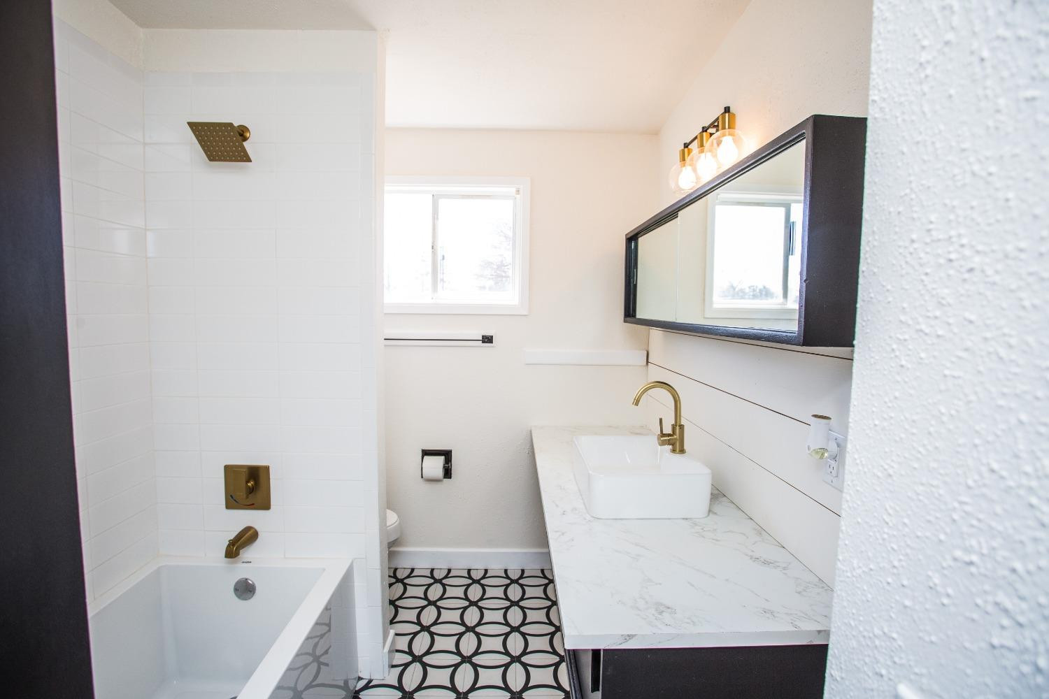 2728 66th Street Lubbock, TX 79413 - Photo 11 of 22 a bathroom with a sink a toilet and shower