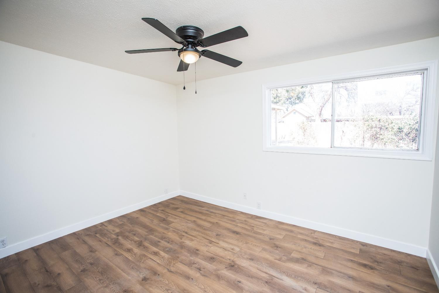 2728 66th Street Lubbock, TX 79413 - Photo 12 of 22 an empty room with a window and a fan