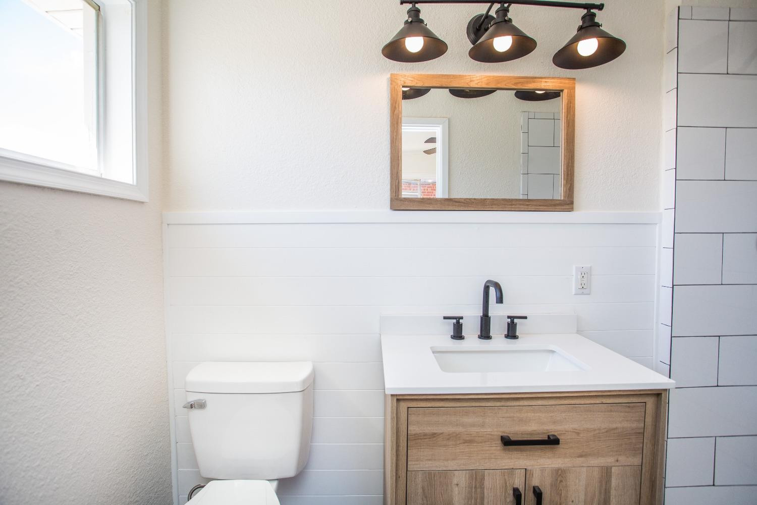 2728 66th Street Lubbock, TX 79413 - Photo 16 of 22 a bathroom with a toilet a sink and mirror