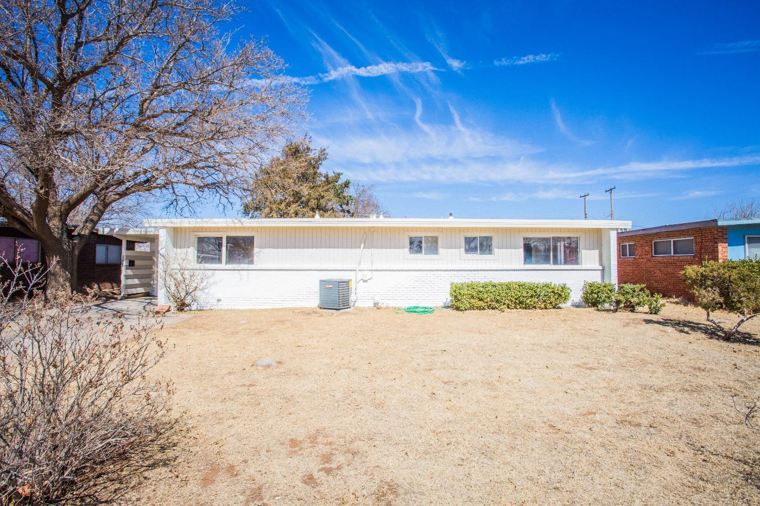 2728 66th Street Lubbock, TX 79413 - Photo 2 of 22 a front view of house with yard and trees in the background