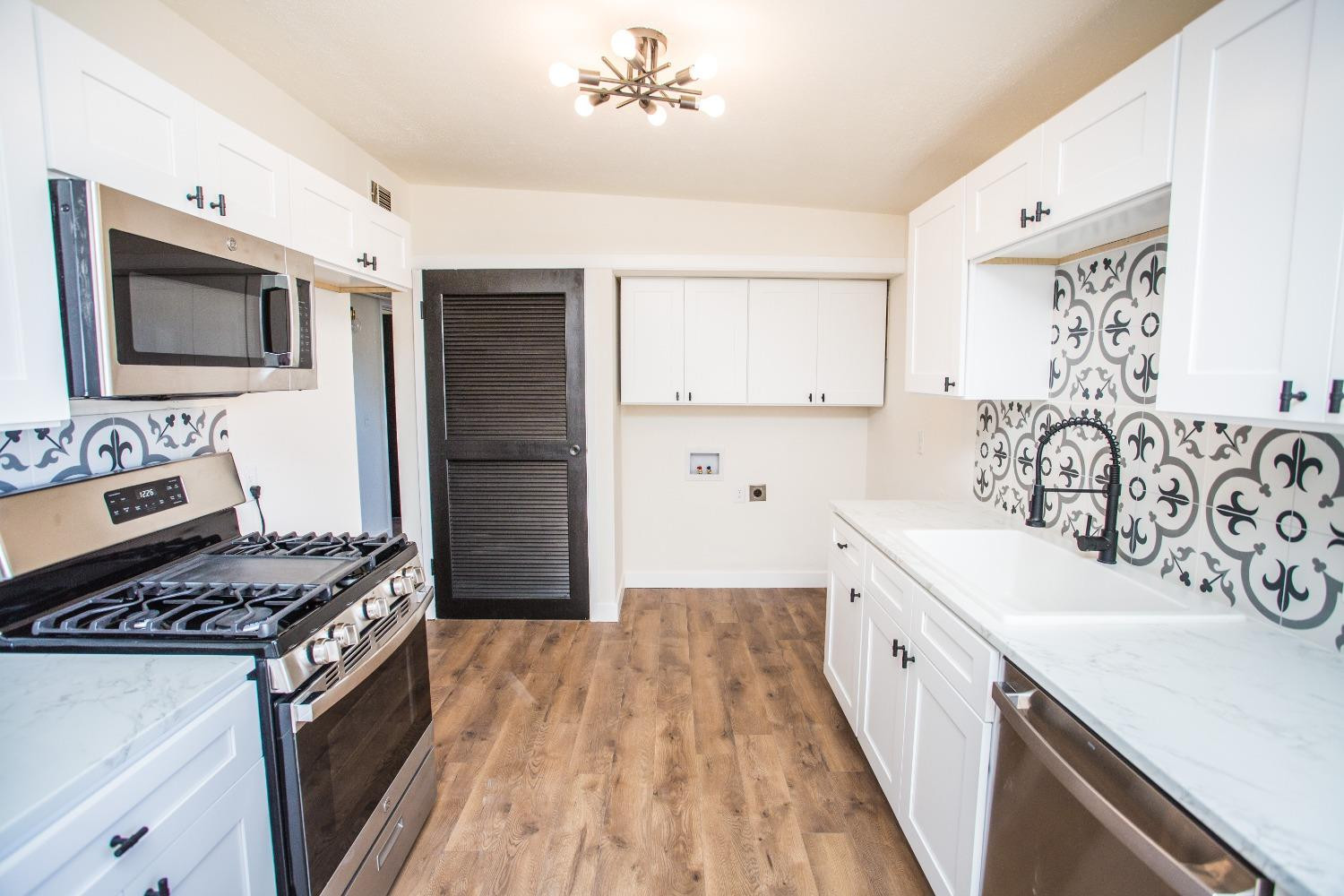 2728 66th Street Lubbock, TX 79413 - Photo 4 of 22 a kitchen with stainless steel appliances granite countertop a sink stove and refrigerator