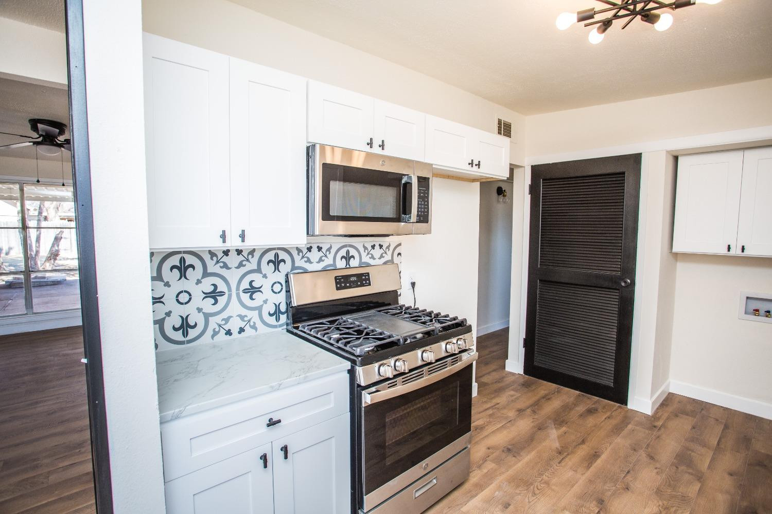 2728 66th Street Lubbock, TX 79413 - Photo 6 of 22 a kitchen with stainless steel appliances white cabinets a stove and a refrigerator