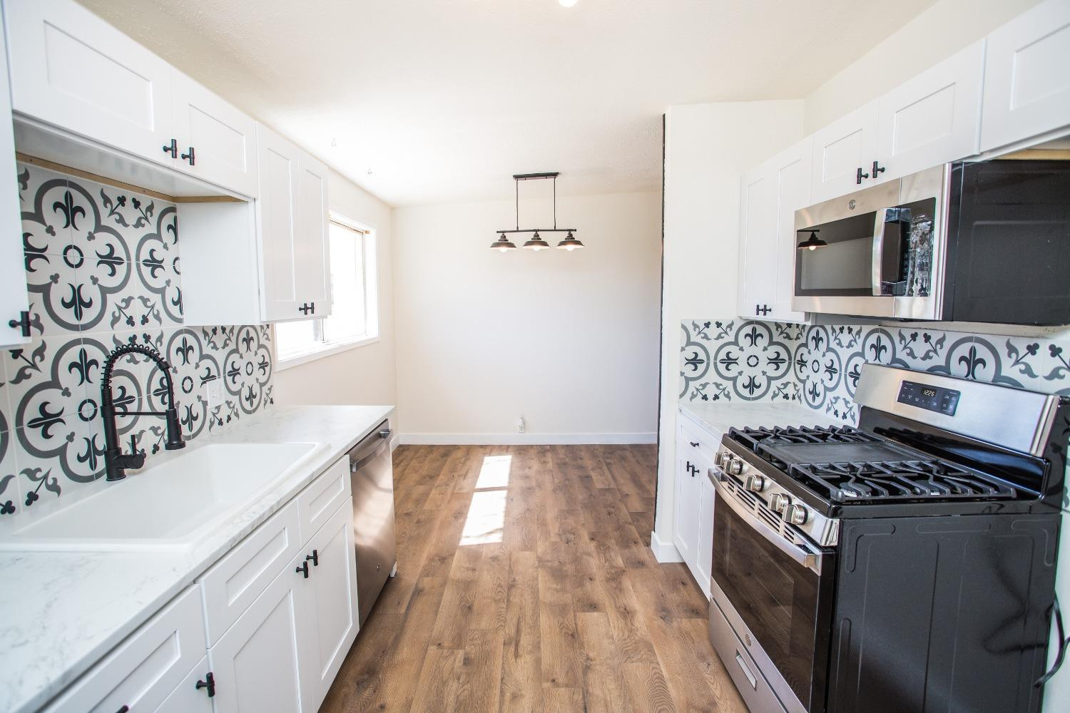 2728 66th Street Lubbock, TX 79413 - Photo 7 of 22 a kitchen with granite countertop a stove and a sink