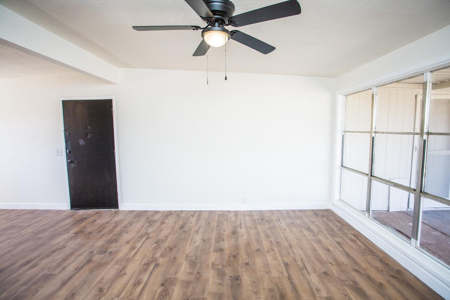 2728 66th Street Lubbock, TX 79413 - Photo 9 of 22 a view of a room with wooden floor and a ceiling fan