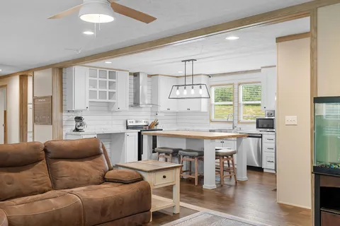 a living room with stainless steel appliances granite countertop furniture and a kitchen view