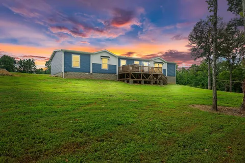 a view of a house with a yard and sitting area