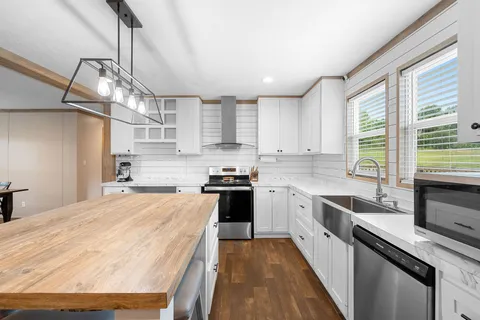 a kitchen with stainless steel appliances sink stove and cabinets