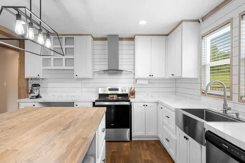 a kitchen with stainless steel appliances granite countertop a sink stove and cabinets