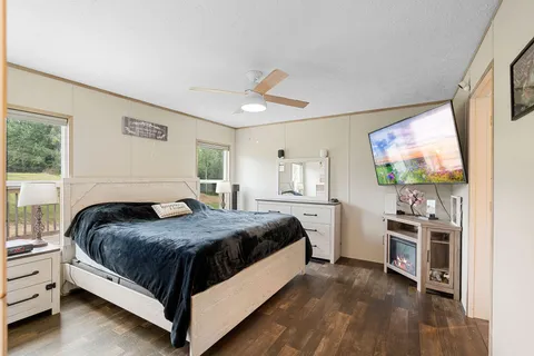 a bedroom with a bed and a flat screen tv